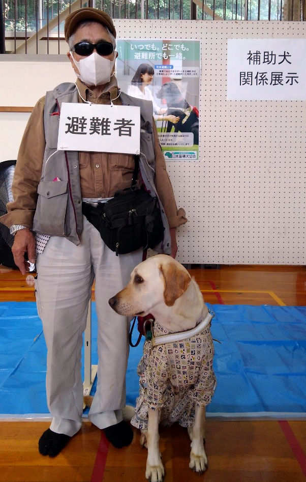 避難訓練に参加する石田さんとクベルの写真